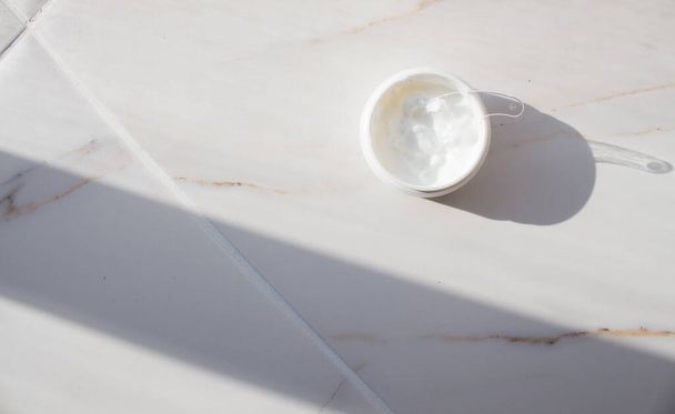 Cream in a jar on marble. Spa layout with text space. Preservation of youth, smoothing wrinkles, skin care. - Φωτογραφία, εικόνα