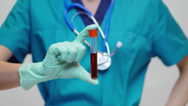 лікар медсестра жінка в захисній масці і латексних рукавичках тримає пробірку крові
  - Кадри, відео