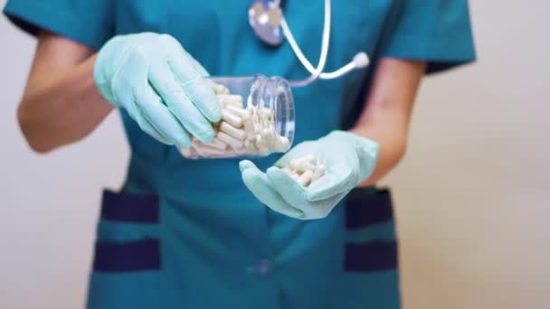 лікар медсестра жінка в захисній масці і гумі або латексних рукавичках тримає таблетки
  - Кадри, відео