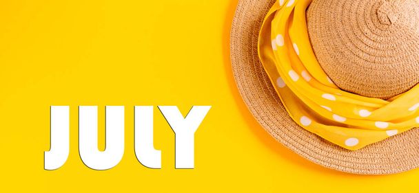 Hasır şapkalı sarı bir arka planda Temmuz harfleriyle yazılmış. Yaz tatili kavramı, tatil. Pankart. - Fotoğraf, Görsel