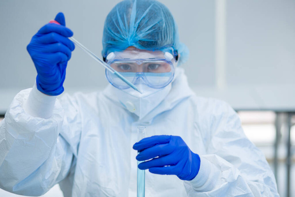 Scientist or researcher hand in blue gloves holding flu, measles, coronavirus, covid-19 vaccine disease preparing for human clinical trials vaccination shot, medicine and drug concept. - Foto, Bild