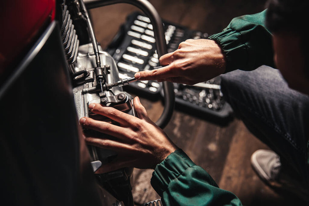 Male hands close-up with wrenches. The auto mechanic works in the garage. Repair service. - 写真・画像