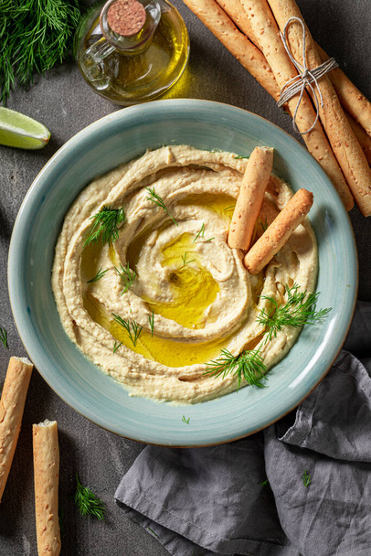 Tasty and fresh hummus with breadsticks and dill - Fotoğraf, Görsel