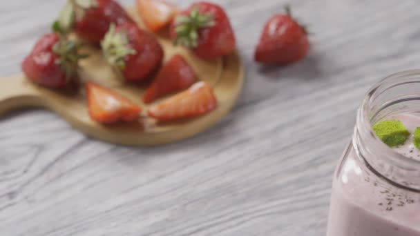 fresh homemade milkshake from strawberries, milk and chia seeds in glass bowl  - Materiał filmowy, wideo