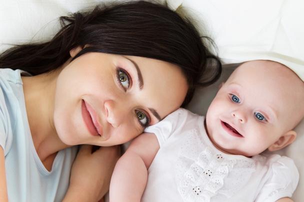 Onnellinen hymyilevä äiti kuuden kuukauden ikäisen tytön kanssa
 - Valokuva, kuva