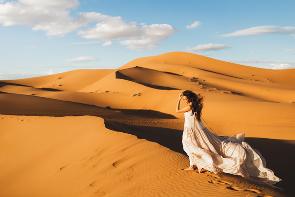 Donna in abito da sposa di seta incredibile con fantastica vista delle dune di sabbia del deserto del Sahara in luce del tramonto. Paesaggio del Marocco, Africa. - Foto, immagini