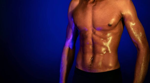 Homem muscular com perfeito abdominais posando em fundo azul, cortado
 - Foto, Imagem