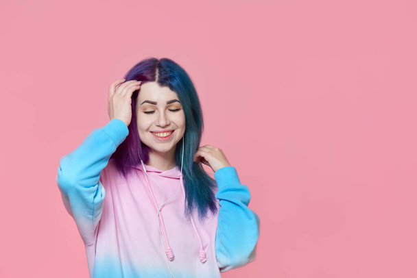 Happy girl listening to music on a pink background - Photo, image