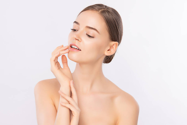Schöne junge Frau berührt ihr sauberes Gesicht mit frischer gesunder Haut, isoliert auf weißem Hintergrund, Kosmetik und Gesichtsbehandlung. - Foto, Bild