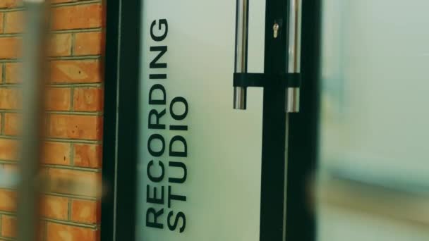 Un homme en jeans bleu entre dans les studios d'enregistrement de la porte
 - Séquence, vidéo
