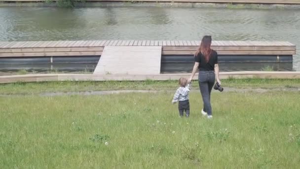 Boy with mom go on a wooden pier - Imágenes, Vídeo