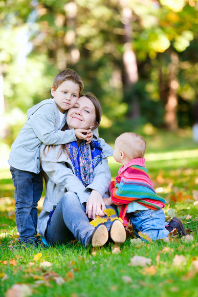 Mother and two kids sitting on grass - Fotografie, Obrázek