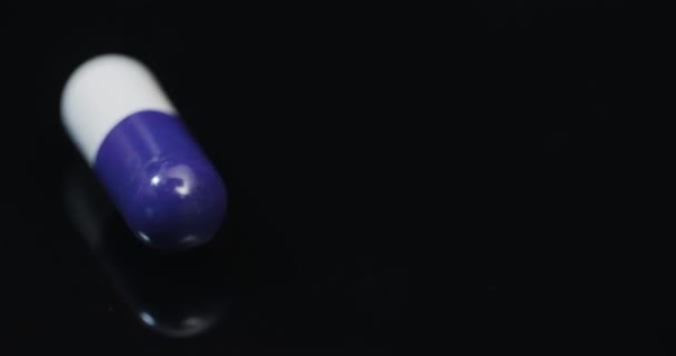 Medicijn Farmacie Concept - Extreme Close-up van de pil draaien op zwarte achtergrond - Video