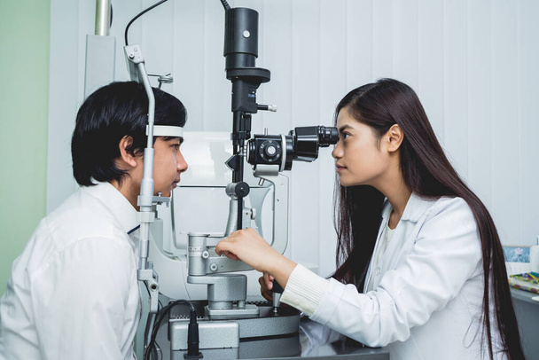 Consultation with an ophthalmologist. Young asian man and woman doctor  - Foto, imagen