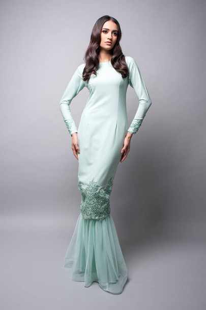 Mooi vrouwelijk model met Maleisië traditionele stof of jurk bekend als "BAJU KURUNG". FASHIE VOOR STEUNMAATREGELEN. - Foto, afbeelding