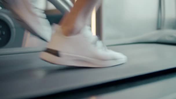 Closeup αρσενικά πόδια κινείται σε διάδρομο γυμναστικής σε αργή κίνηση. - Πλάνα, βίντεο