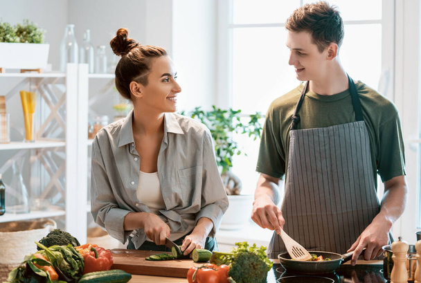 Healthy food at home. Happy loving couple is preparing the proper meal in the kitchen.  - Zdjęcie, obraz