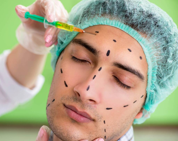 Plastic surgeon preparing for operation on man face - Photo, Image