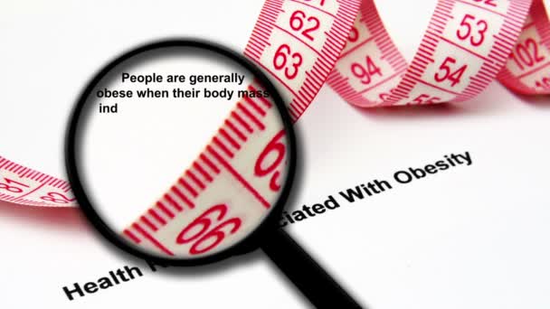 Μεγέθυνση γυαλί για την έννοια της παχυσαρκίας - Πλάνα, βίντεο