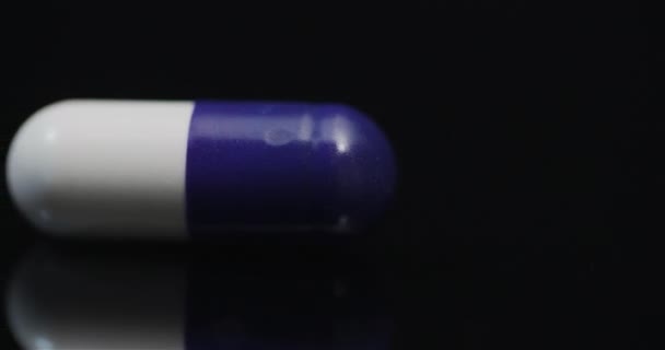 Одна медицинская таблетка вращается на черном фоне
 - Кадры, видео