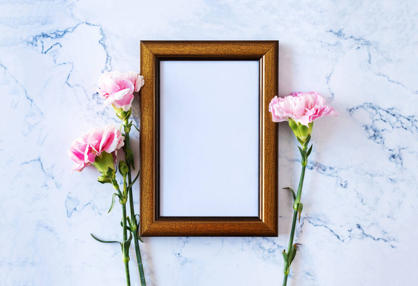 Гвоздичный цветок на пустой рамке на мраморном фоне, День Святого Валентина, День матери или День рождения
 - Фото, изображение