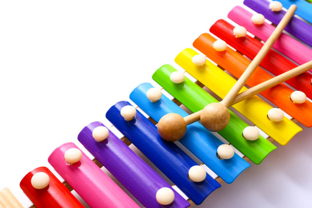 Rainbow colored wooden toy xylophone with two sticks on white background. - Photo, Image