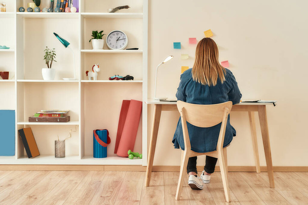 Creative workplace. Young woman in casual clothes sitting at office desk, working or studying at home office. Working remotely - Foto, Imagen