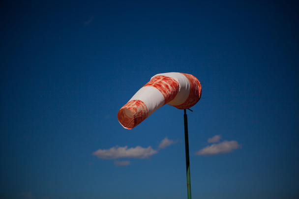rode windvaan tegen een blauwe hemel - Foto, afbeelding