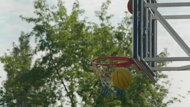 Een basket scoren in een basketbalring op training. Basketbalbord. Slow motion shot - Video