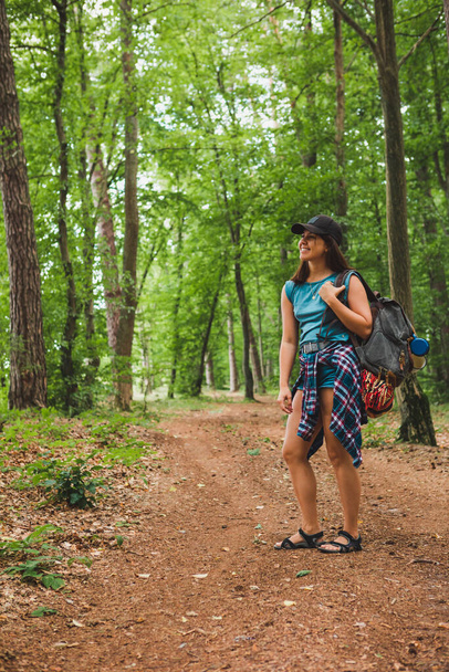 νεαρή ενήλικη γυναίκα περπάτημα με σακίδιο πλάτης από μονοπάτι του δάσους - Φωτογραφία, εικόνα