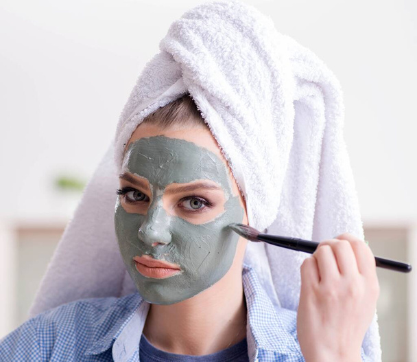 Kadın evde fırçayla kilden maske takıyor - Fotoğraf, Görsel