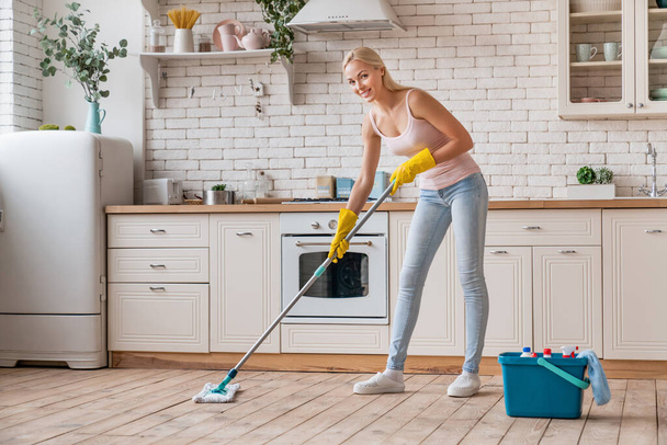 Woman with mop cleaning kitchen floor - Fotoğraf, Görsel