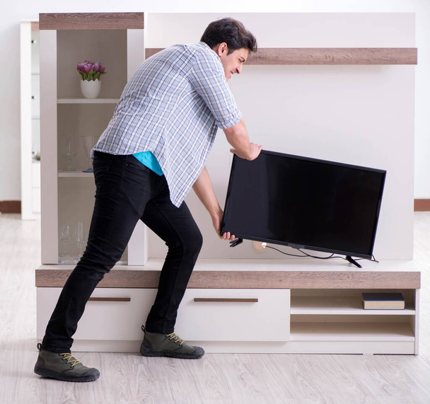 Mann versucht kaputten Fernseher zu reparieren - Foto, Bild