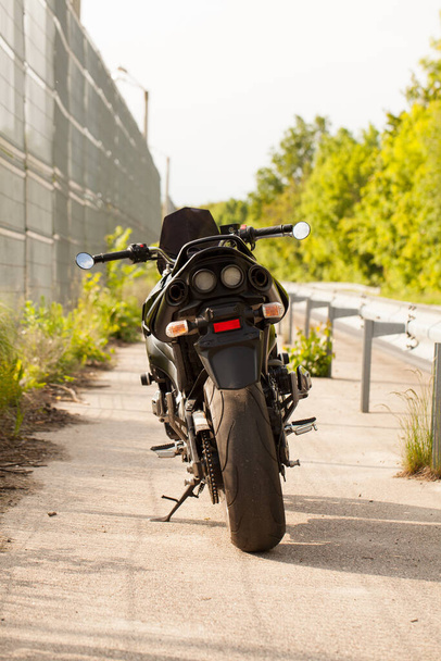 Zwarte motorfiets op de weg. - Foto, afbeelding