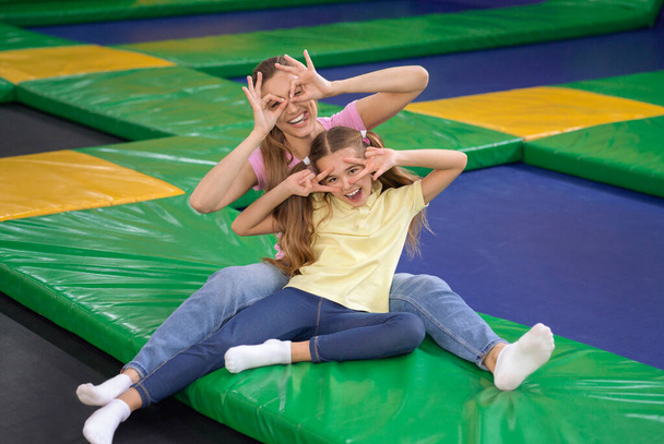 Cute child with mom fooling around at trampoline park - Foto, Imagem