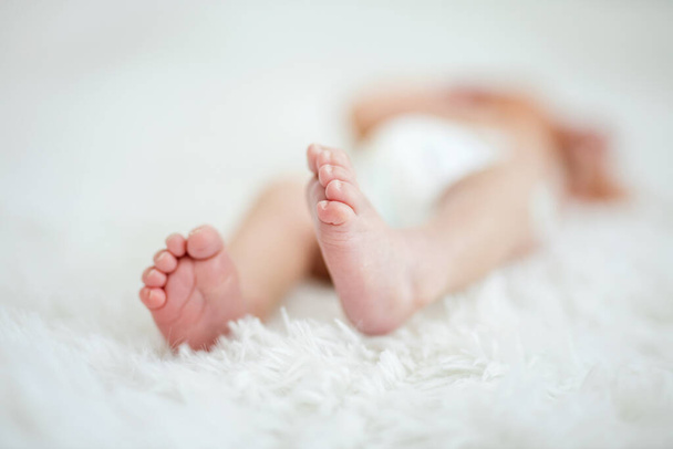 Primer plano de los pies del bebé recién nacido, imagen con poca profundidad de campo
 - Foto, imagen