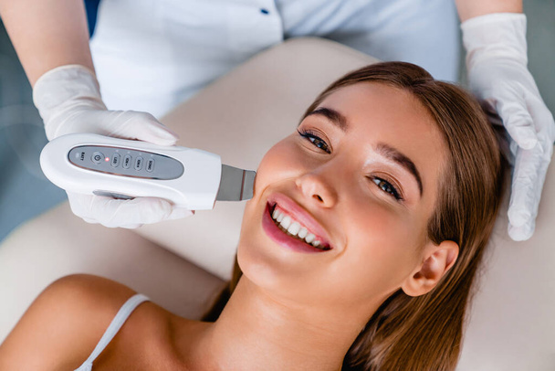 Smiling caucasian female on ultrasound facial beauty treatment - Foto, immagini