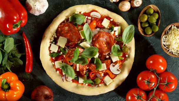 Top view of pizza meal preparation, raw ingredients around. Italian traditional meal. - Foto, Imagem