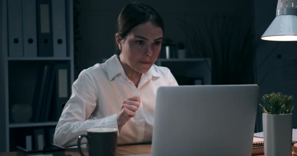 Zakenvrouw ontvangt slecht nieuws op laptop op nachtkantoor - Video
