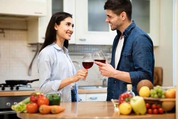 Charmant couple buvant du vin dans la cuisine de leur appartement
 - Photo, image
