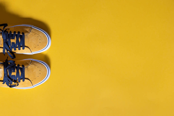 horizontal mockup, mustard colored shoes on a yellow background, copy space to the right - Photo, Image