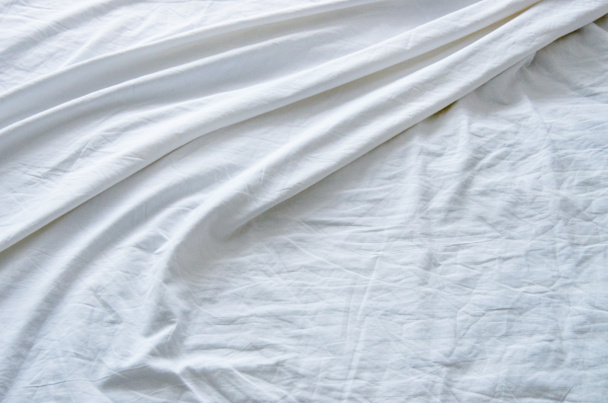 Top view of wrinkles on an unmade bed sheet after waking up in the morning. - Photo, Image