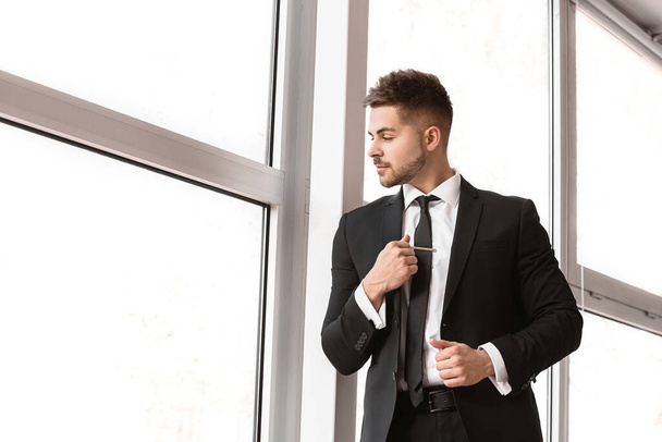 Handsome young man in elegant suit near window - Zdjęcie, obraz