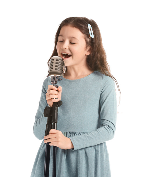 Χαριτωμένο κοριτσάκι τραγουδά σε λευκό φόντο - Φωτογραφία, εικόνα