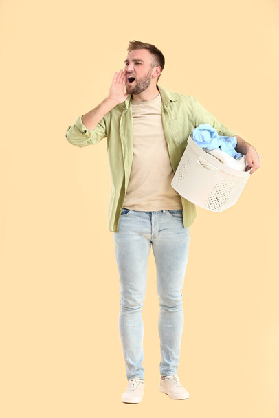 Screaming man with laundry on color background - Photo, Image