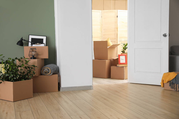 Cardboard boxes with belongings in new flat on moving day - Photo, Image