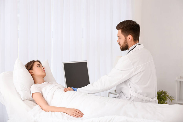 Male doctor working with patient in hospital room - Photo, Image