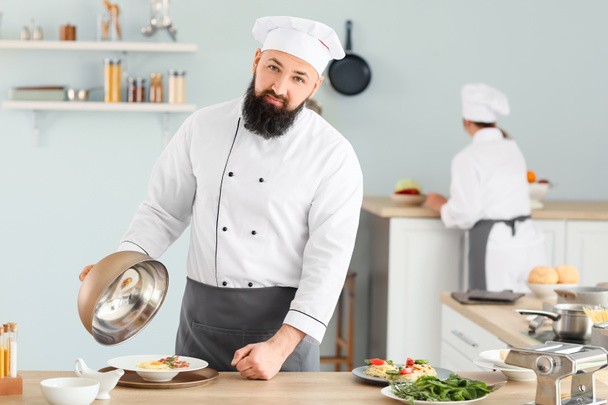 Male chef with tasty dish in kitchen - Photo, Image