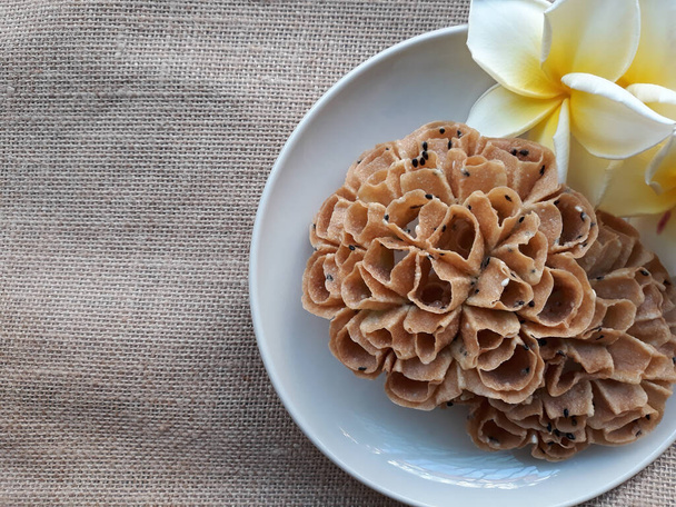 Текстурный фон тайских закусок название "каном-дурк йорк" на блюде с цветами. Пространство для текста
 - Фото, изображение