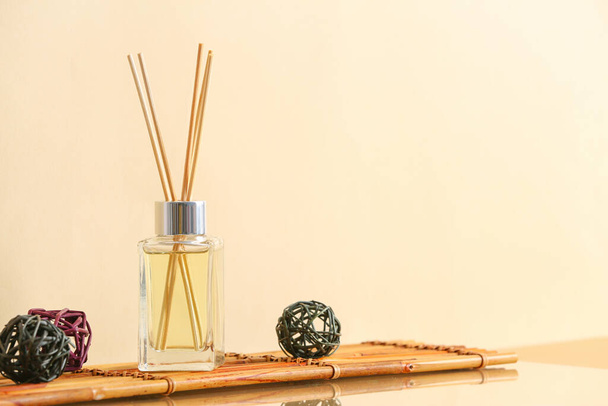 Reed diffuser on table against color background - Foto, imagen